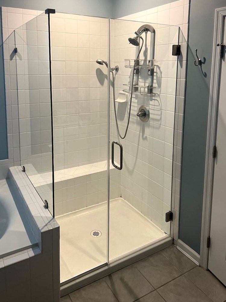 New frameless shower door and panel in the same opening, after replacement