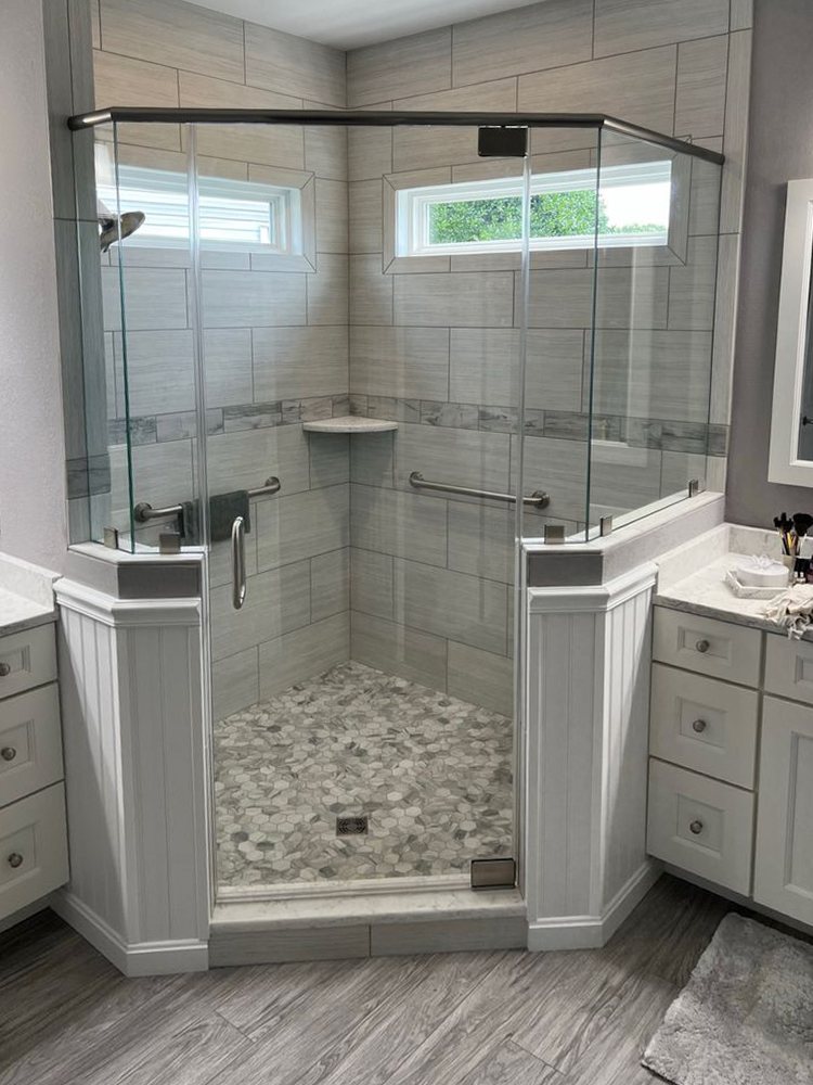 Neo-angle glass shower enclosure set between two bathroom vanities
